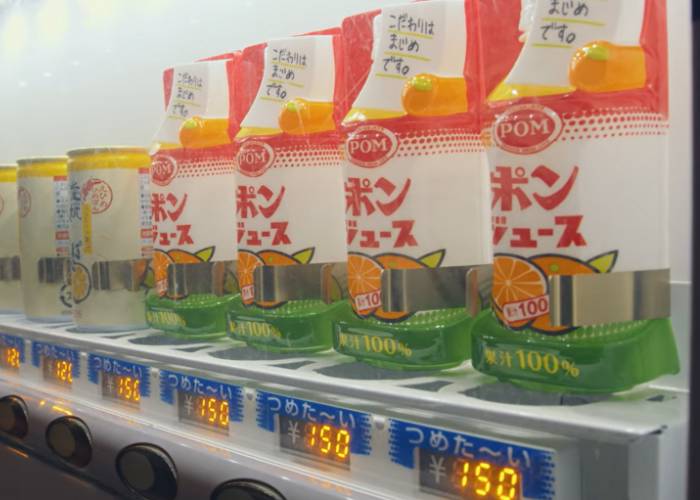 A Pom orange juice vending machine, showing off the different orange juice flavors for sale.